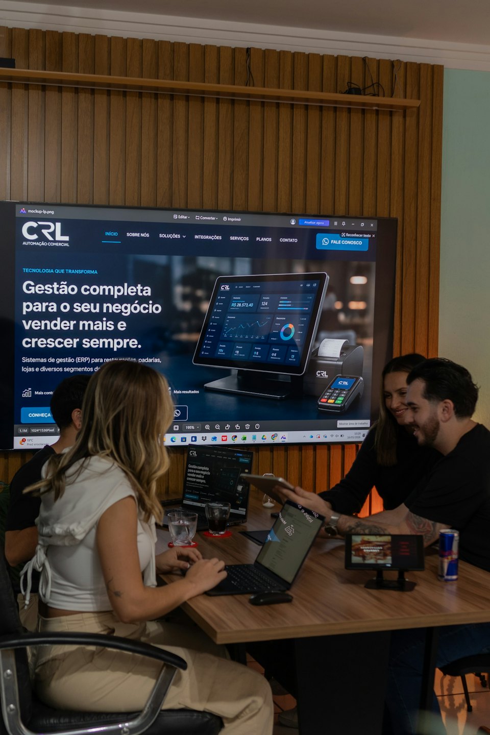 Team reviewing CRL Automação Comercial ERP system on laptops and tablet.